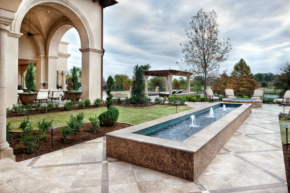 Expansive mediterranean backyard patio in Houston with a water feature and no cover.
