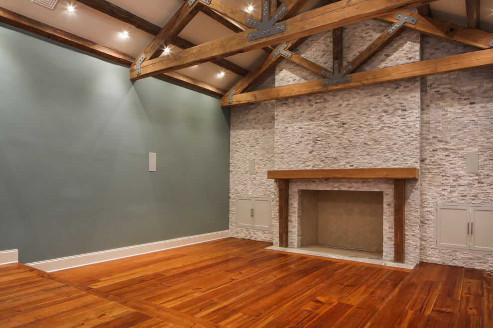 Photo of a large transitional enclosed home theatre in New Orleans with green walls, medium hardwood floors, a projector screen and brown floor.
