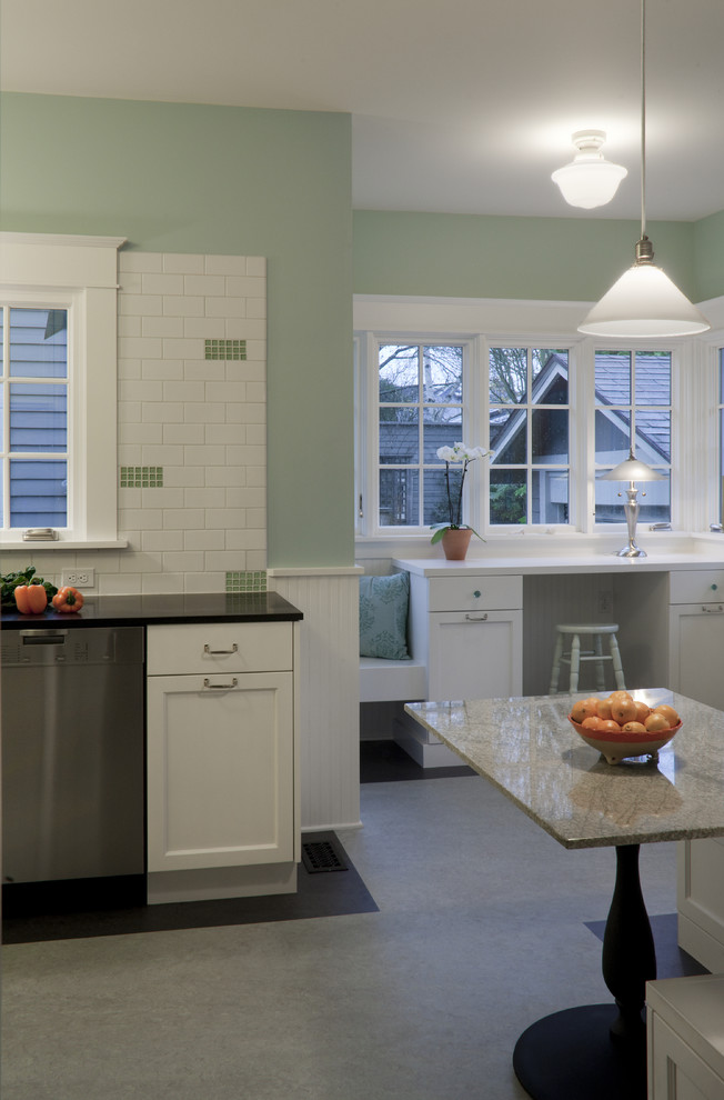 This is an example of a mid-sized arts and crafts galley eat-in kitchen in Portland with shaker cabinets, white cabinets, granite benchtops, white splashback, subway tile splashback, stainless steel appliances, linoleum floors and no island.