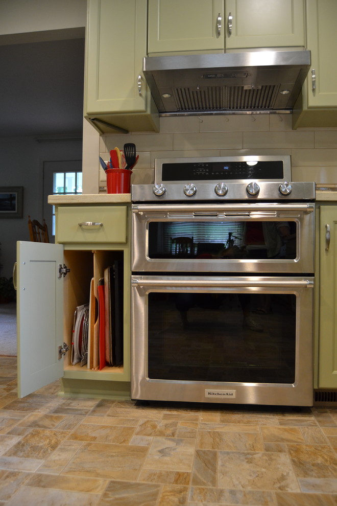 Inspiration for a mid-sized transitional l-shaped ceramic tile and beige floor eat-in kitchen remodel with shaker cabinets, green cabinets, stainless steel appliances and no island