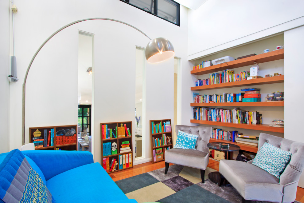 Inspiration for a large contemporary study room in Sydney with beige walls, medium hardwood floors, a built-in desk and brown floor.