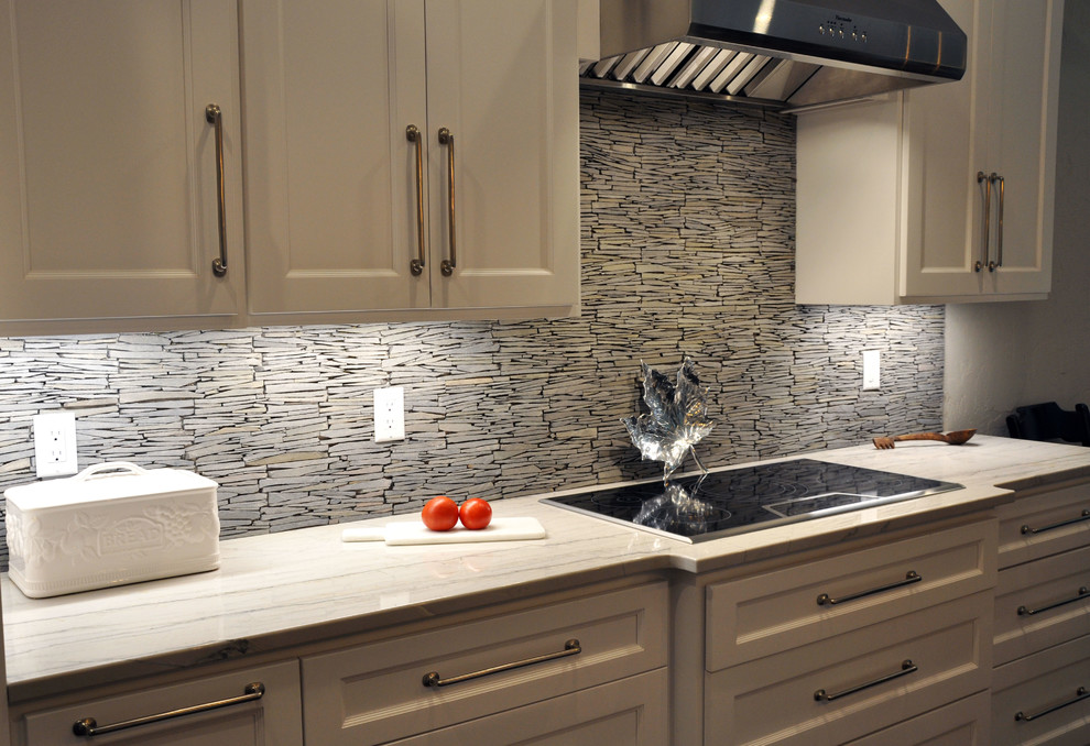 Example of a large mountain style u-shaped dark wood floor and brown floor eat-in kitchen design in Milwaukee with recessed-panel cabinets, white cabinets, granite countertops, gray backsplash, stone tile backsplash, stainless steel appliances, an island and an undermount sink
