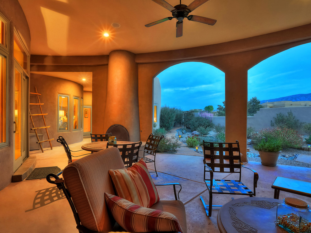 Design ideas for a large backyard patio in Albuquerque with with fireplace, stamped concrete and a roof extension.