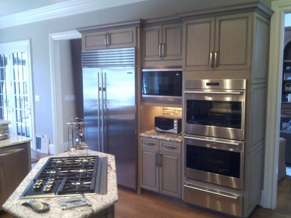 Mid-sized transitional l-shaped eat-in kitchen photo with a single-bowl sink, raised-panel cabinets, gray cabinets, granite countertops, beige backsplash, glass tile backsplash and an island