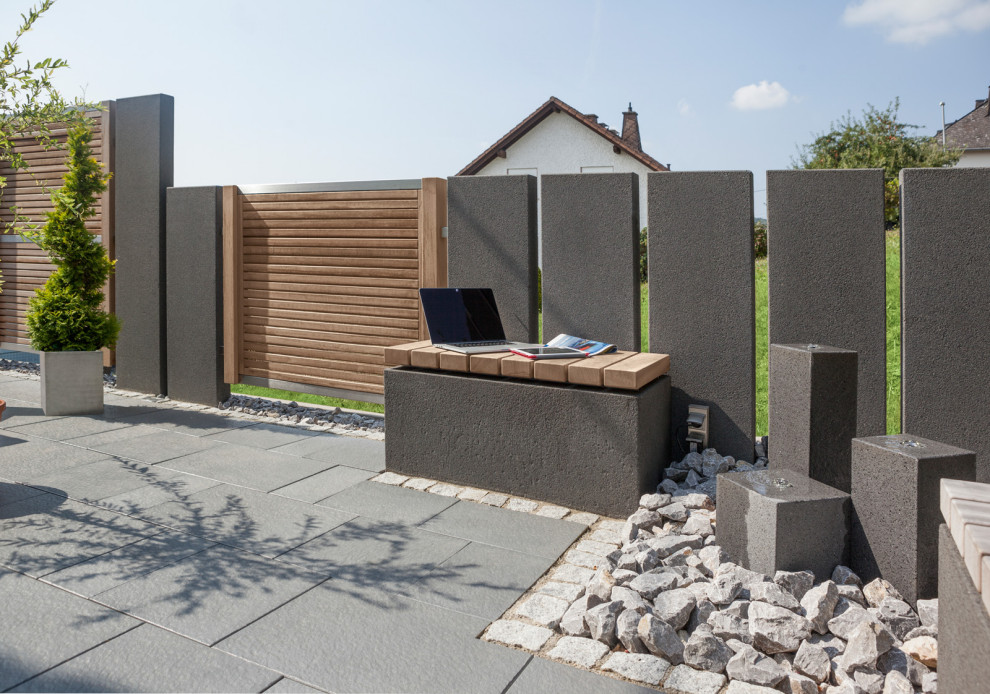 Contemporary garden in Frankfurt with a retaining wall and concrete pavers.