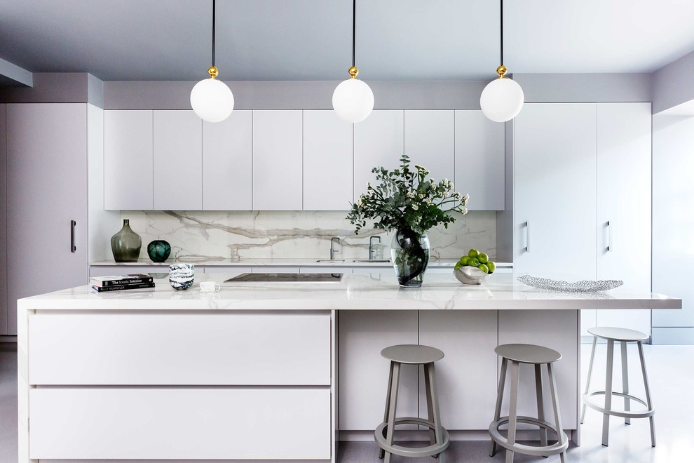 Inspiration for a large contemporary l-shaped eat-in kitchen in London with an undermount sink, flat-panel cabinets, grey cabinets, solid surface benchtops, white splashback, stone slab splashback, white appliances, concrete floors, with island, grey floor and white benchtop.