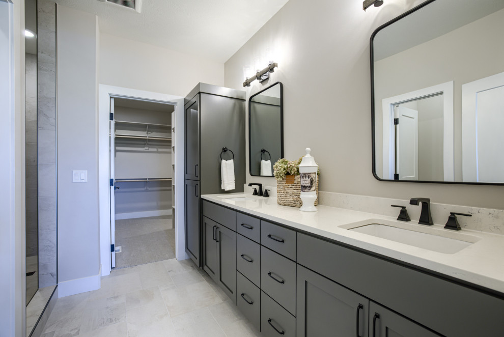 Example of a country master beige floor and double-sink bathroom design in Omaha with shaker cabinets, gray cabinets, a two-piece toilet, an undermount sink, quartz countertops, white countertops and a built-in vanity