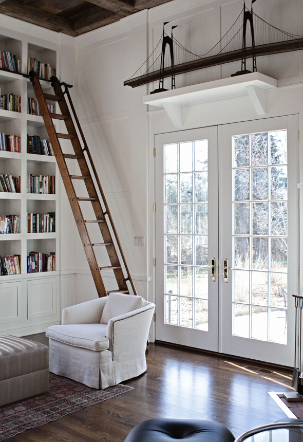 Inspiration for an expansive country home office in New York with a library, white walls, dark hardwood floors, no fireplace and brown floor.