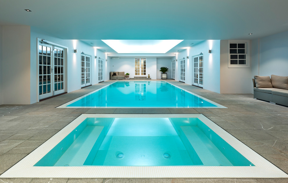 Design ideas for a large contemporary indoor rectangular pool in Melbourne with a pool house and natural stone pavers.