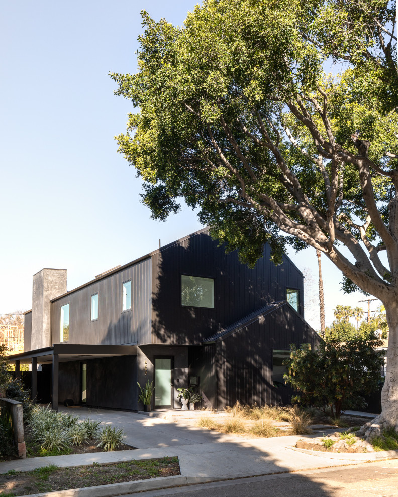 Inspiration for a small modern two-storey black house exterior in Los Angeles with wood siding, a gable roof and a metal roof.
