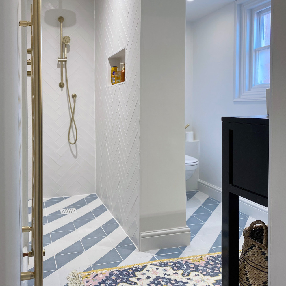 На фото: маленькая детская ванная комната в современном стиле с черными фасадами, открытым душем, унитазом-моноблоком, белой плиткой, керамической плиткой, белыми стенами, полом из керамической плитки, консольной раковиной, столешницей из дерева, синим полом, открытым душем, черной столешницей, тумбой под одну раковину, напольной тумбой и открытыми фасадами для на участке и в саду с