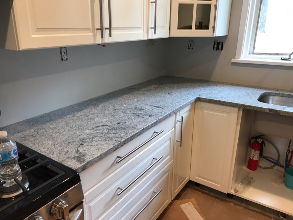 Small l-shaped enclosed kitchen photo with an undermount sink, raised-panel cabinets, white cabinets, granite countertops, stainless steel appliances, no island and gray countertops