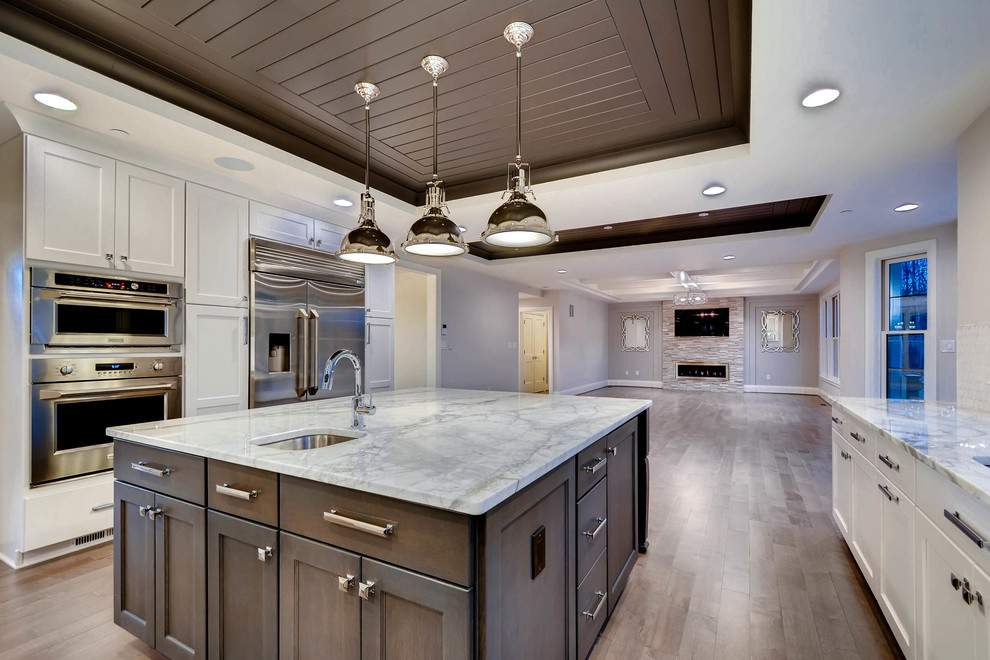 Example of a large transitional u-shaped open concept kitchen design in Baltimore with a single-bowl sink, shaker cabinets, white cabinets, marble countertops, white backsplash, stainless steel appliances and an island