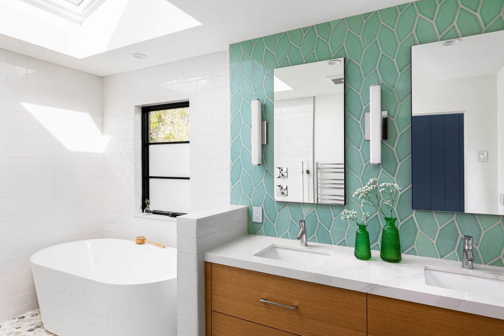 Photo of a mid-sized midcentury master wet room bathroom in Other with flat-panel cabinets, medium wood cabinets, a freestanding tub, a one-piece toilet, green tile, ceramic tile, white walls, ceramic floors, an undermount sink, engineered quartz benchtops, green floor, an open shower, white benchtops, a niche, a double vanity and a floating vanity.