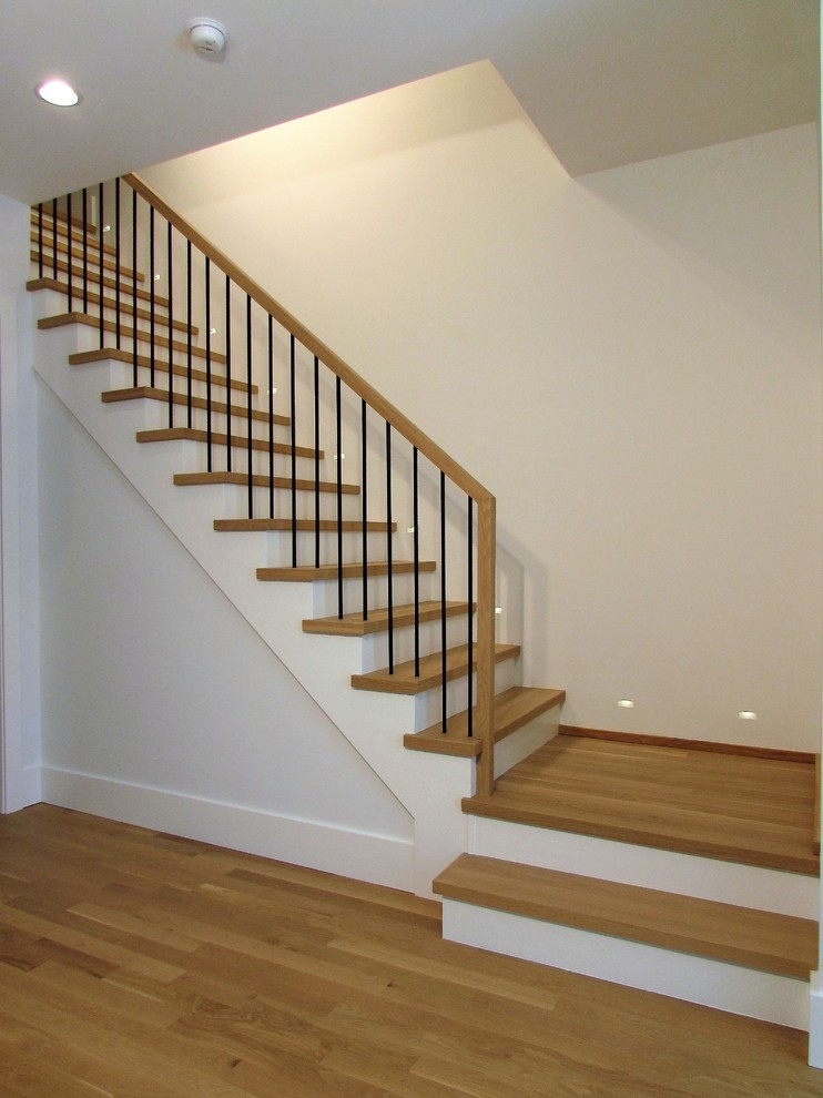 Photo of a large contemporary wood l-shaped staircase in Chicago with wood risers and metal railing.