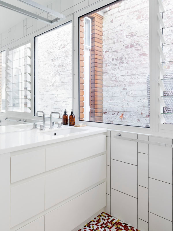 Inspiration for a small contemporary bathroom in Melbourne with white cabinets, solid surface benchtops, an open shower, white tile, ceramic tile, ceramic floors and white walls.