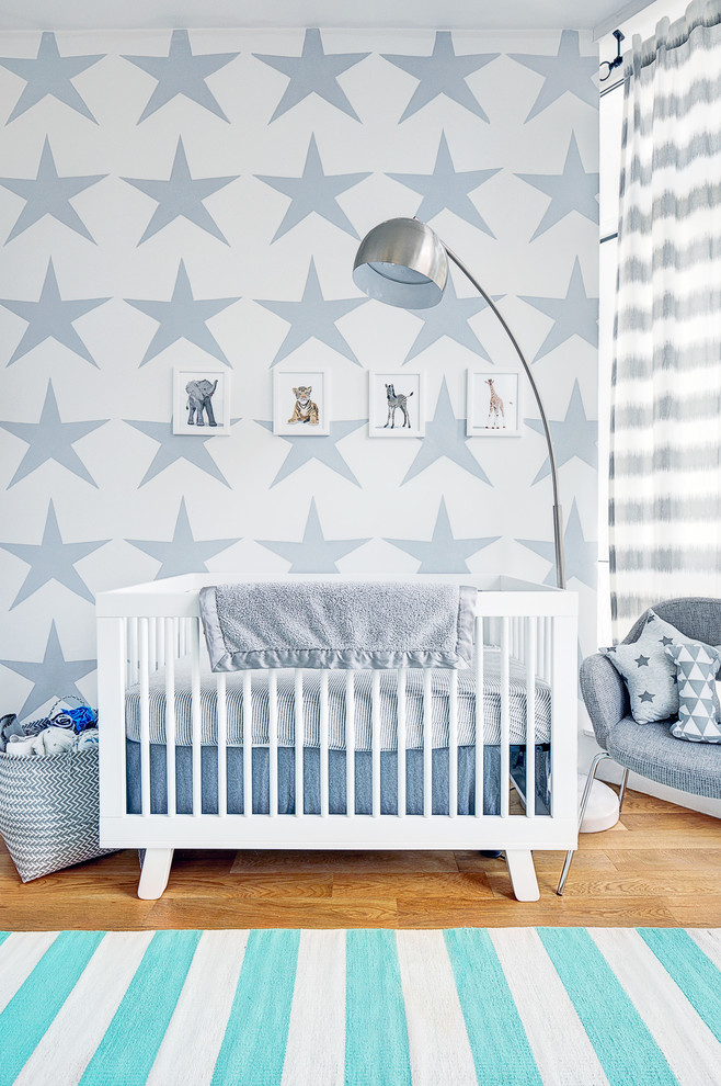 Inspiration for a mid-sized modern nursery for boys in New York with white walls and light hardwood floors.