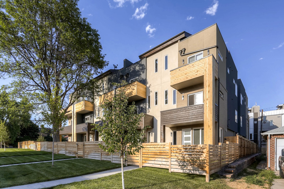 Expansive modern three-storey beige apartment exterior in Denver with a flat roof and mixed siding.