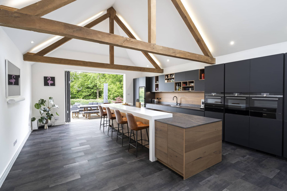 Modern inredning av ett mellanstort flerfärgad linjärt flerfärgat kök med öppen planlösning, med en dubbel diskho, släta luckor, svarta skåp, bänkskiva i kvartsit, brunt stänkskydd, stänkskydd i trä, svarta vitvaror, en köksö och svart golv