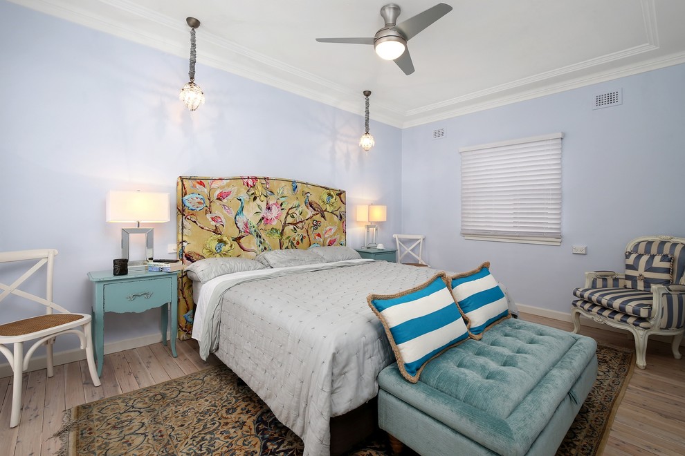 Traditional bedroom in Sydney with blue walls and light hardwood floors.