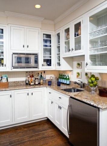 This is an example of a mid-sized traditional galley eat-in kitchen in DC Metro with a drop-in sink, glass-front cabinets, white cabinets, soapstone benchtops, white splashback, stone slab splashback, stainless steel appliances, dark hardwood floors and no island.