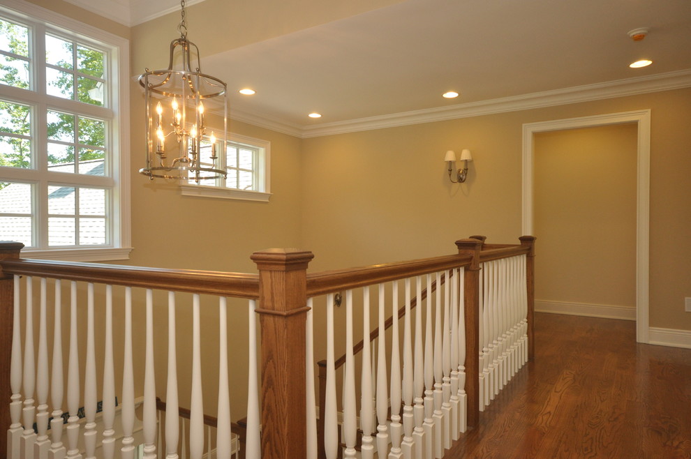 This is an example of a mid-sized traditional wood u-shaped staircase in New York with painted wood risers and wood railing.