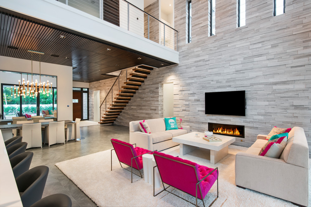 Photo of a contemporary open concept living room in Miami with grey walls, a ribbon fireplace, a wall-mounted tv and grey floor.
