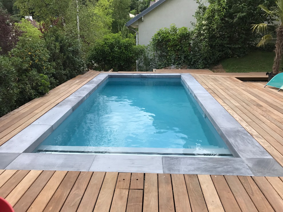 This is an example of a small contemporary front yard rectangular lap pool in Paris with decking.