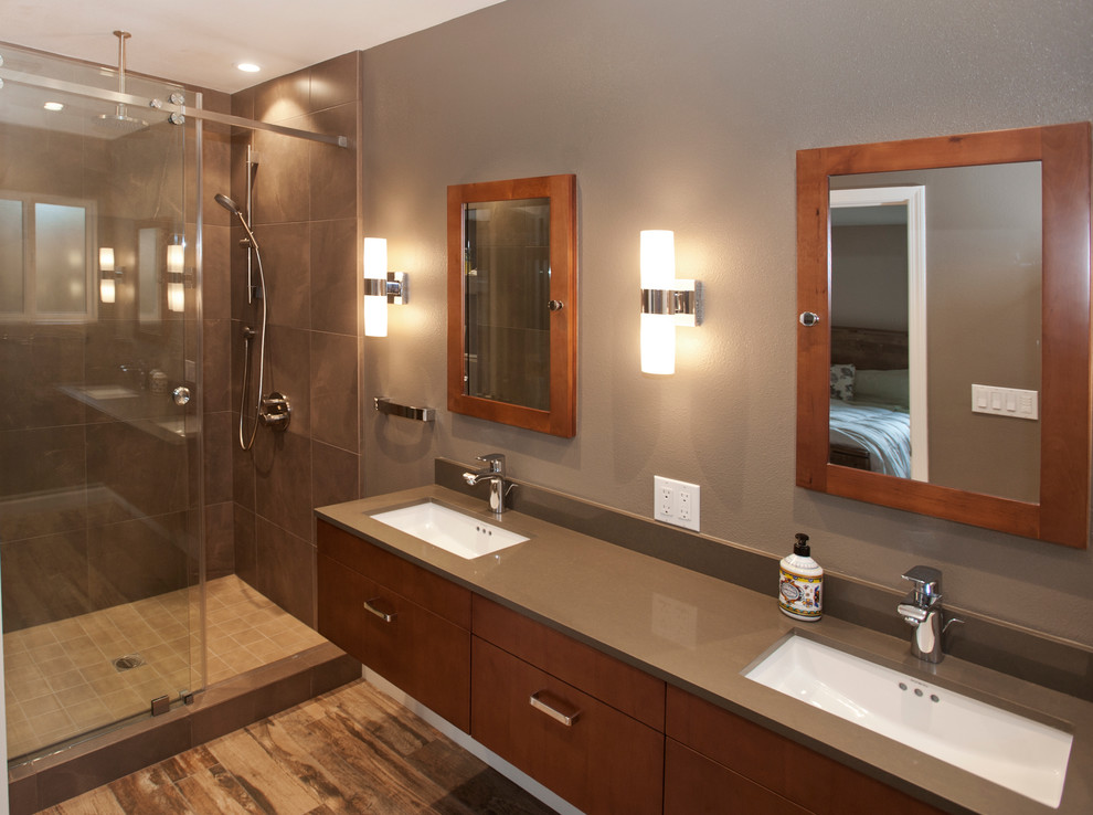 Photo of a large contemporary master bathroom in San Francisco with flat-panel cabinets, dark wood cabinets, an alcove shower, a two-piece toilet, brown tile, stone tile, brown walls, light hardwood floors, an undermount sink and engineered quartz benchtops.