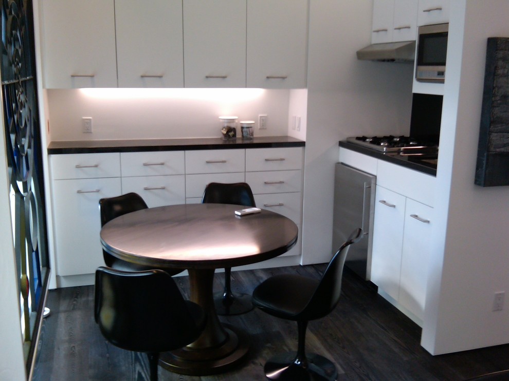 Mid-sized transitional dark wood floor and black floor great room photo in Los Angeles with white walls and no fireplace