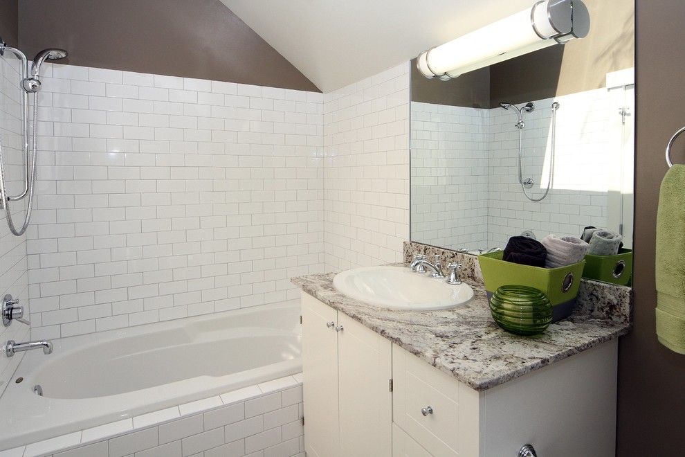 Inspiration for a large transitional 3/4 white tile ceramic tile drop-in bathtub remodel in Calgary with a drop-in sink, white cabinets, granite countertops and white walls