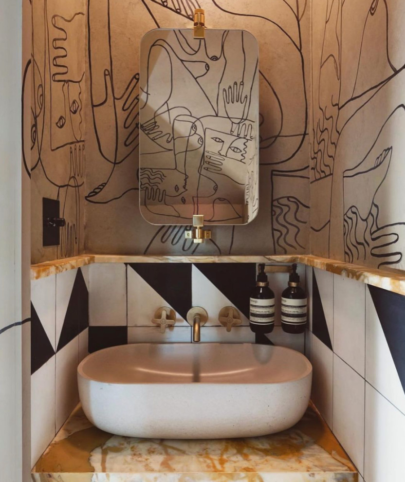 Inspiration for a small nautical cloakroom in Other with a wall mounted toilet, black and white tiles, cement tiles, beige walls, concrete flooring, a built-in sink, black floors, a vaulted ceiling and wallpapered walls.