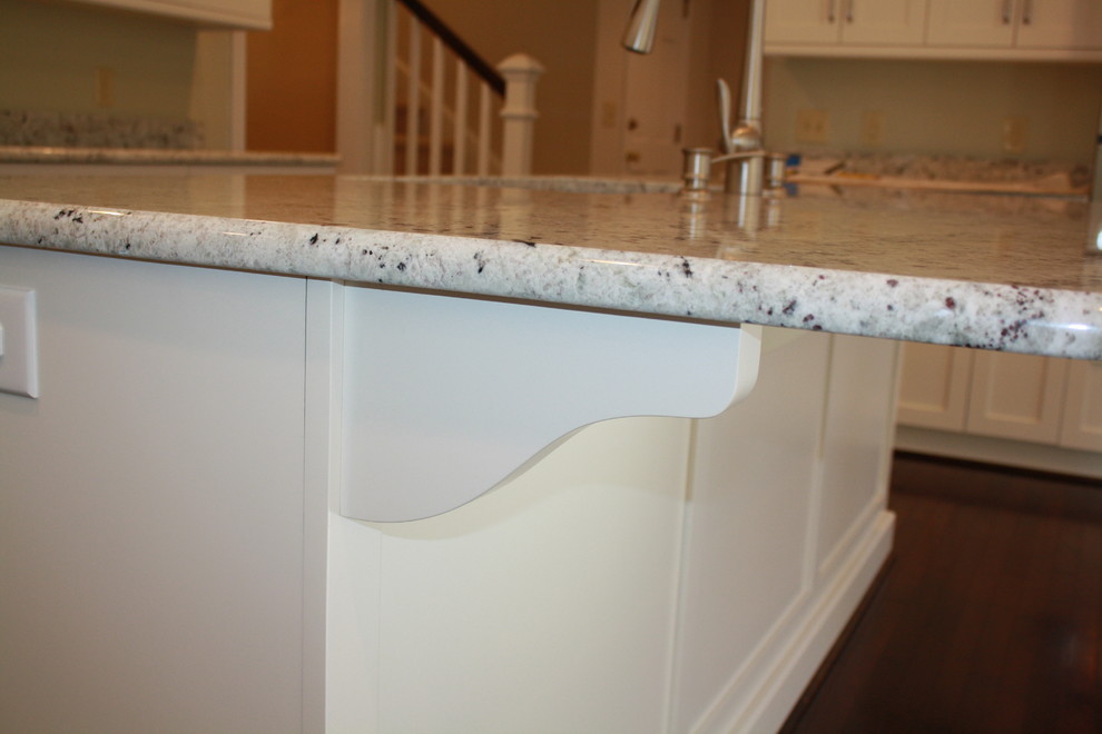 Example of a mid-sized transitional u-shaped dark wood floor kitchen design in Charlotte with recessed-panel cabinets, white cabinets, granite countertops, stainless steel appliances and an island
