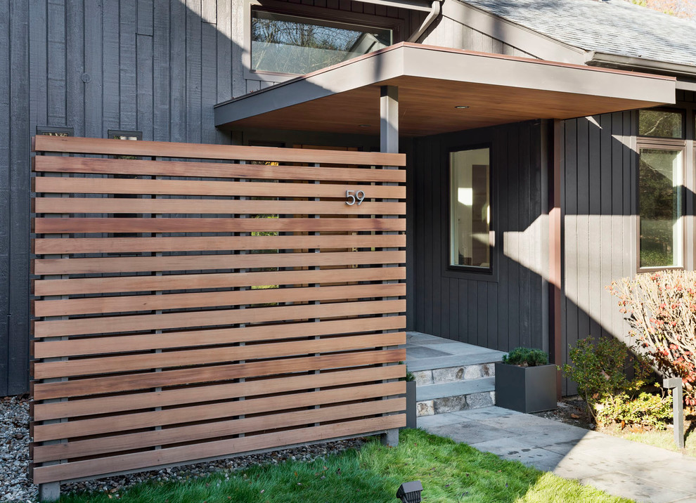 Inspiration for a mid-sized contemporary two-storey black exterior in New York with wood siding and a shed roof.