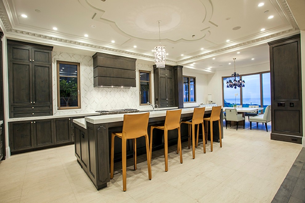 Large transitional l-shaped open concept kitchen photo in Orange County with a single-bowl sink, recessed-panel cabinets, gray cabinets, marble countertops, white backsplash, paneled appliances and an island