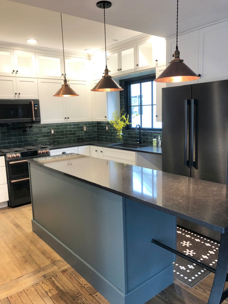 Photo of a medium sized classic l-shaped open plan kitchen in Grand Rapids with a submerged sink, shaker cabinets, white cabinets, engineered stone countertops, green splashback, porcelain splashback, black appliances, medium hardwood flooring, an island, brown floors and black worktops.