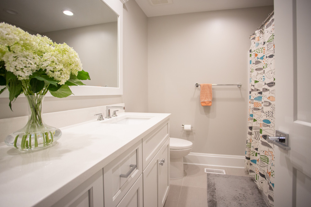 Mid-sized traditional bathroom in Columbus with shaker cabinets, white cabinets, an alcove tub, a two-piece toilet, gray tile, grey walls, ceramic floors, an undermount sink, engineered quartz benchtops, grey floor, a shower curtain, white benchtops, a single vanity and a built-in vanity.