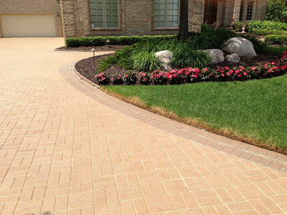 Inspiration for a large front driveway garden in Detroit with brick paving.