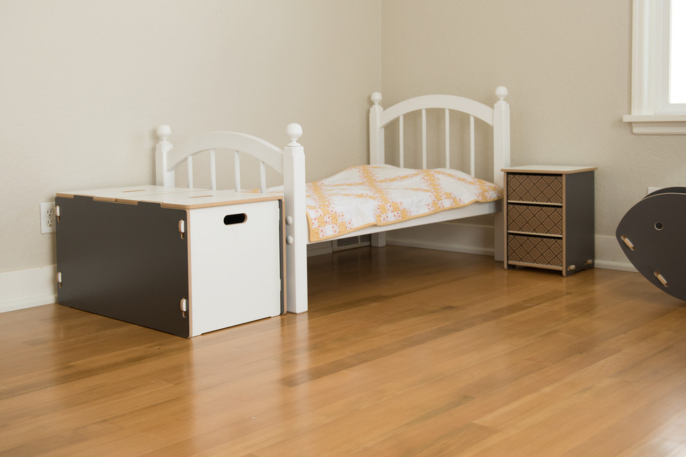 This is an example of a mid-sized modern gender-neutral kids' bedroom for kids 4-10 years old in Salt Lake City with white walls and light hardwood floors.