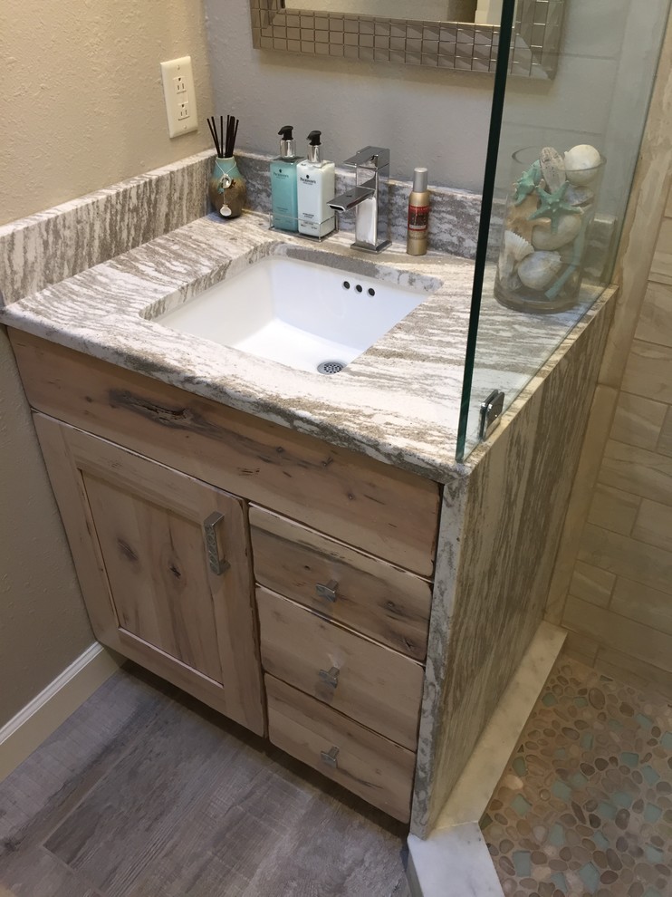 Design ideas for a mid-sized beach style bathroom in Cleveland with shaker cabinets, distressed cabinets, beige walls, porcelain floors, an undermount sink and quartzite benchtops.