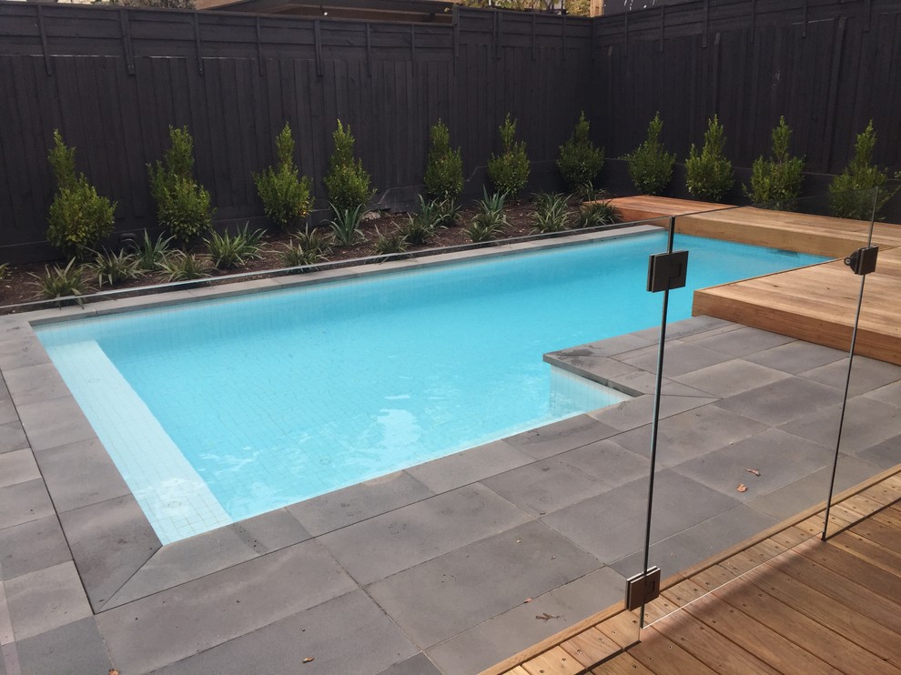 Mid-sized contemporary backyard custom-shaped lap pool in Melbourne with natural stone pavers.