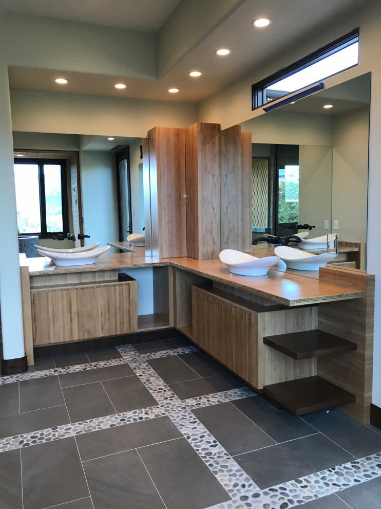 This is an example of a medium sized contemporary ensuite bathroom in Phoenix with flat-panel cabinets, medium wood cabinets, a freestanding bath, a corner shower, a bidet, beige walls, porcelain flooring, a vessel sink, wooden worktops, grey floors, a hinged door, an enclosed toilet, double sinks and a built in vanity unit.