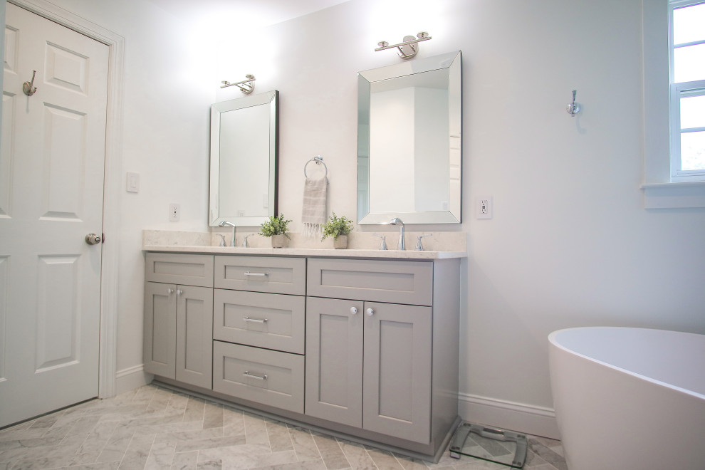 Contemporary master bathroom in Charlotte with shaker cabinets, grey cabinets, a freestanding tub, a corner shower, a two-piece toilet, white walls, an undermount sink, quartzite benchtops, a hinged shower door, white benchtops, a niche, a double vanity and a built-in vanity.
