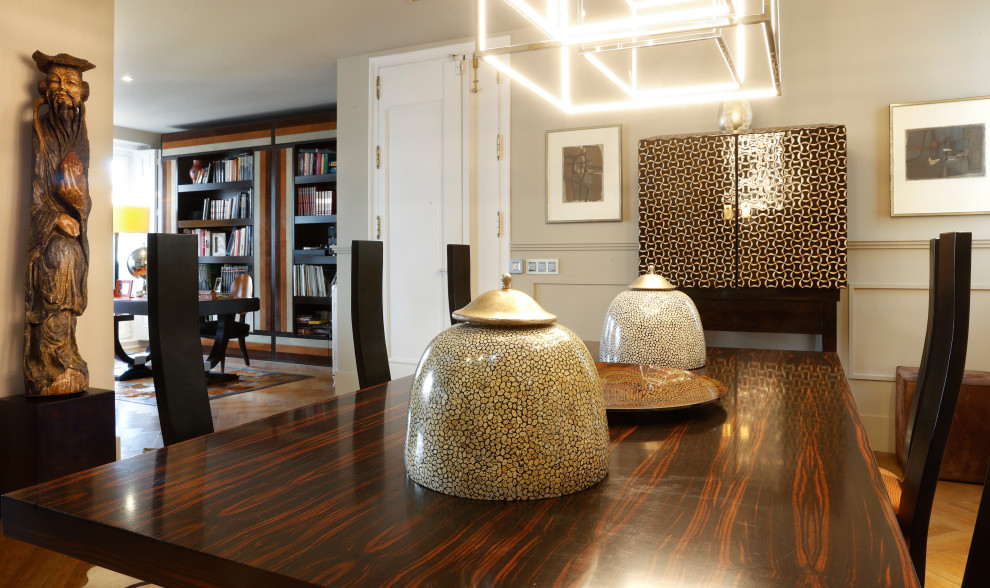 Imagen de salón ecléctico con suelo de madera clara y televisor retractable