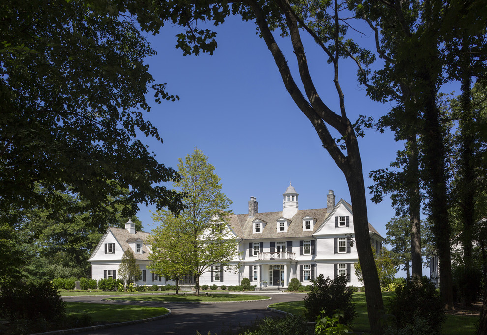 Photo of an expansive traditional three-storey white house exterior in New York with wood siding and a shingle roof.