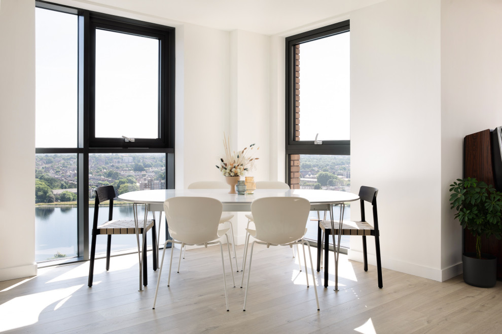 Immagine di una sala da pranzo aperta verso il soggiorno moderna di medie dimensioni con pareti bianche, pavimento in legno massello medio e pavimento beige