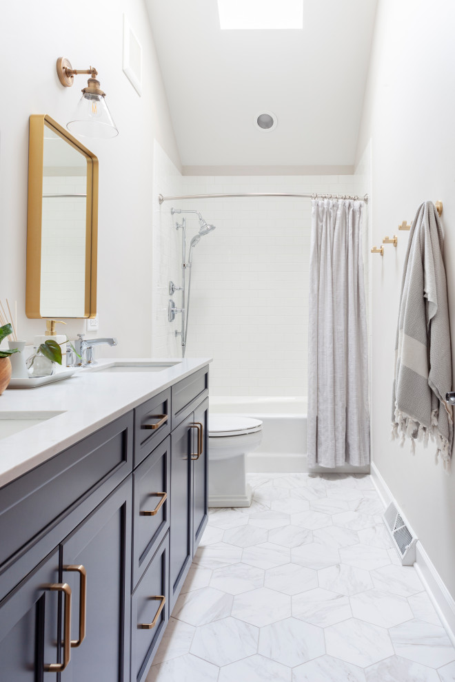 Idéer för att renovera ett litet funkis vit vitt en-suite badrum, med skåp i shakerstil, blå skåp, ett platsbyggt badkar, en dusch/badkar-kombination, en toalettstol med hel cisternkåpa, vit kakel, keramikplattor, vita väggar, marmorgolv, ett konsol handfat, bänkskiva i kvartsit, vitt golv och dusch med duschdraperi