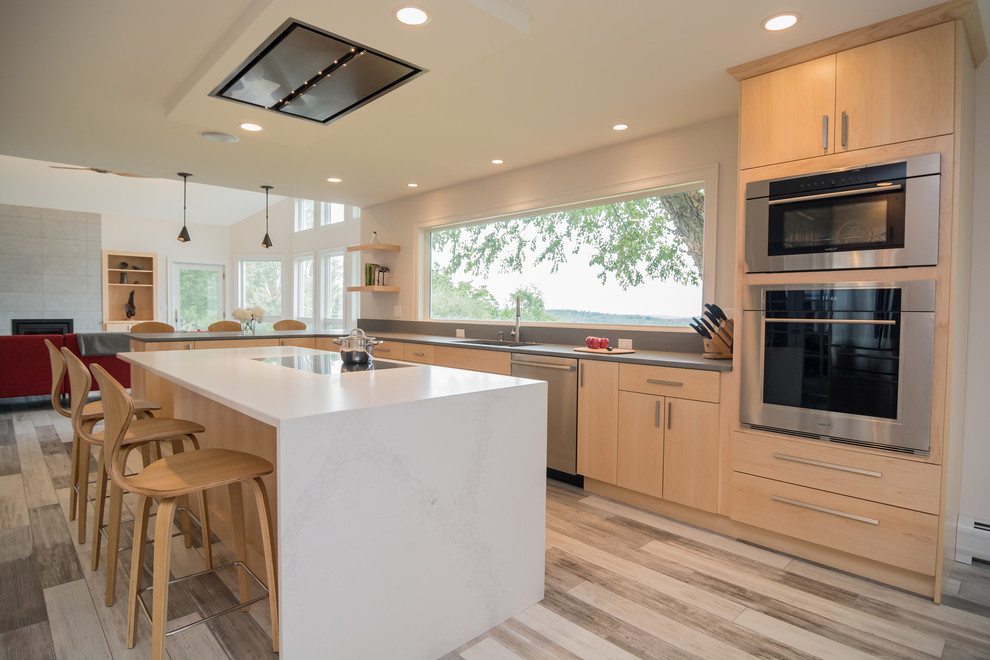 Design ideas for an expansive contemporary u-shaped open plan kitchen in Boston with an undermount sink, flat-panel cabinets, light wood cabinets, quartz benchtops, stainless steel appliances, with island and multi-coloured floor.