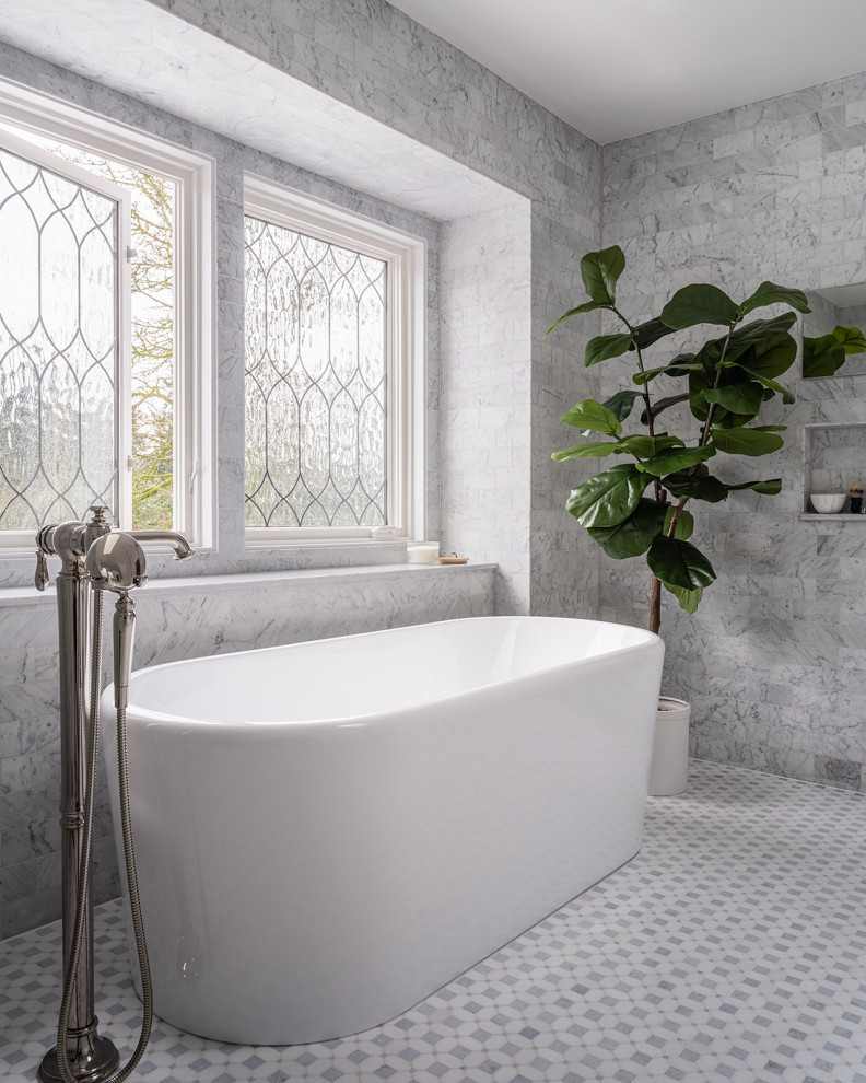 Пример оригинального дизайна: огромная главная ванная комната в классическом стиле с фасадами в стиле шейкер, белыми фасадами, отдельно стоящей ванной, двойным душем, унитазом-моноблоком, серой плиткой, мраморной плиткой, белыми стенами, полом из мозаичной плитки, врезной раковиной, столешницей из искусственного кварца, синим полом, открытым душем, белой столешницей, сиденьем для душа, тумбой под две раковины, встроенной тумбой и обоями на стенах