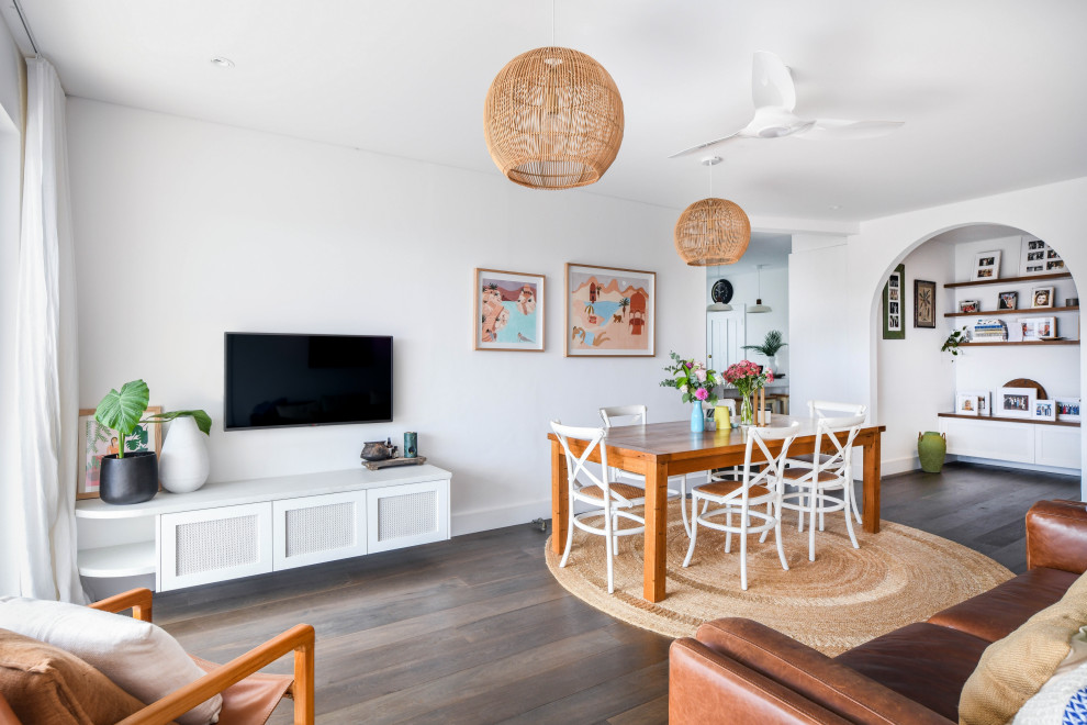 Inspiration for a mid-sized beach style open concept living room in Sydney with white walls, dark hardwood floors, no fireplace, a wall-mounted tv and brown floor.